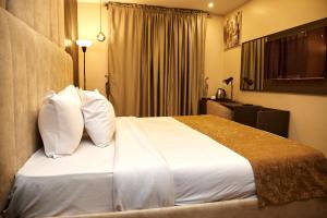 Rúm í herbergi á Mayfair Hotel Wuse2 Abuja
