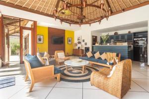 a living room with a couch and chairs and a table at Beautiful Villa Indah in Seminyak