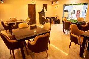 um restaurante com mesas e cadeiras num quarto em Mayfair Hotel Wuse2 Abuja em Abuja