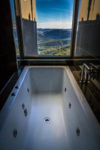 a bath tub in a bathroom with a window at Binna Burra Sky Lodges in Beechmont