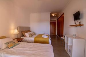 a hotel room with two beds and a television at Amazing Apartment With Pool View in Vilamoura