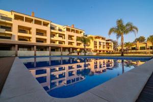 a swimming pool in front of a hotel at Amazing Apartment With Pool View in Vilamoura