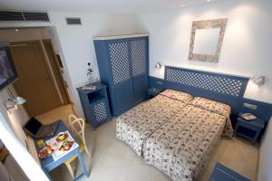 a small bedroom with a bed and a mirror at Hotel Katja in Bibione