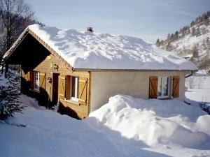 ein schneebedecktes Haus mit einem Stapel Schnee in der Unterkunft Chalet confortable avec cheminée proche de La Bresse-Hohneck, idéal pour famille et amis. - FR-1-589-123 in La Bresse