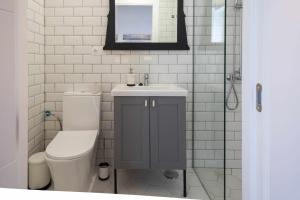 a bathroom with a toilet and a sink and a mirror at Casa Portus Gaditanus s XVIII Patio Andaluz in El Puerto de Santa María +43 photos