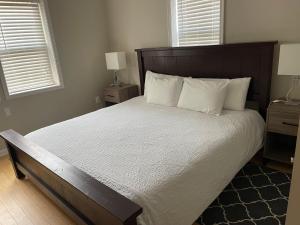 華盛頓的住宿－The Gray Corner House by Gallaudet 3 BR 2 BA，卧室配有一张带白色床单和枕头的大床。