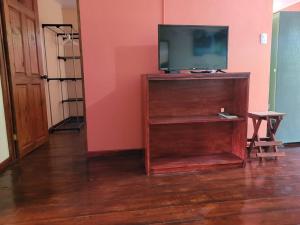 uma televisão em cima de um centro de entretenimento de madeira em Casa Vero 2 em Cahuita