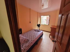 um pequeno quarto com uma cama e uma janela em Casa Vero 2 em Cahuita