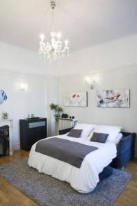 a bedroom with a large bed and a chandelier at Home Sweet Home Claridge 1bedroom in Paris