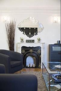 a living room with a fireplace with a mirror at Home Sweet Home Claridge 1bedroom in Paris