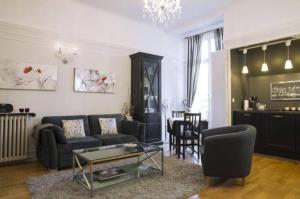 a living room with a couch and a table at Home Sweet Home Claridge 1bedroom in Paris