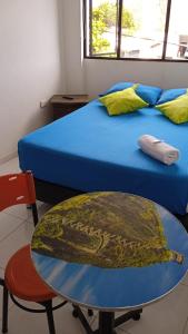 Zimmer mit einem Tisch, einem Bett, einem Tisch und einem Stuhl in der Unterkunft HOTEL ANAPOIMA PLAZA IN in Anapoima