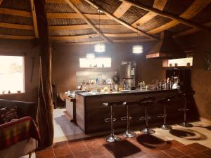 a kitchen with a counter and stools in a room at Refugio Andino con vista al volcán. in San Pedro de Atacama