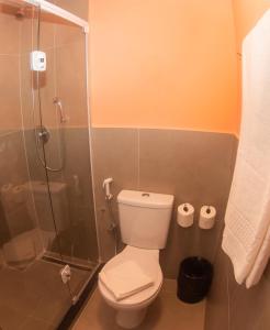a bathroom with a toilet and a glass shower at Ibis Styles Garanhuns in Garanhuns