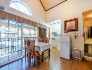 a kitchen with a table and chairs and a refrigerator at Gilson Story Pension in Pyeongchang