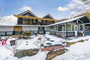 a large house with snow on the ground at Gilson Story Pension in Pyeongchang