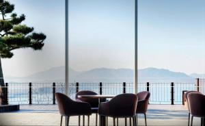 uma mesa e cadeiras com vista para a água em Hotel Hyundai by Lahan Mokpo em Mokpo