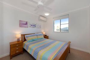 Schlafzimmer mit einem Bett und einem Fenster in der Unterkunft Pacific Links 1b in Bargara