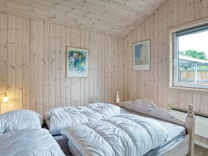 um quarto com quatro camas e uma janela em Holiday home Nykøbing Sj XL em Nyrup