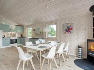 uma cozinha com uma mesa e cadeiras e uma lareira em Holiday home Nykøbing Sj XL em Nyrup