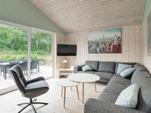 uma sala de estar com um sofá e uma mesa em Holiday home Nykøbing Sj XL em Nyrup