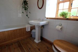a bathroom with a sink and a tub and a toilet at Larkrise Cottage Bed And Breakfast in Stratford-upon-Avon