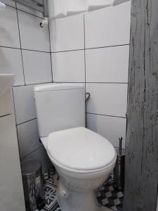 トルンにあるBeautiful Apartmentの白いタイル張りのバスルーム(白いトイレ付)