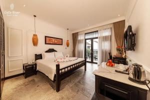 a bedroom with a bed and a television in it at Hoi An Coco River Resort & Spa in Hoi An