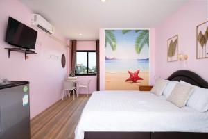 a bedroom with a white bed and a large window at Brown Home Sattahip @ 19 in Sattahip