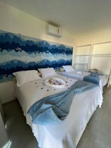 Schlafzimmer mit einem Bett mit Wandgemälde in der Unterkunft Aloha Gostoso in São Miguel do Gostoso
