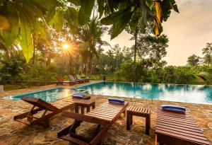 a swimming pool with benches and a picnic table at Serenity Boutique - Unawatuna in Unawatuna