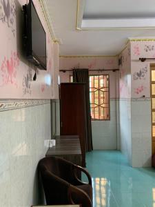 a waiting room with a chair and a tv on the wall at Minh Tuan Hotel in Ho Chi Minh City