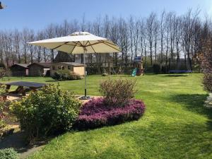 park z parasolem i stołem piknikowym w obiekcie La Pose Normande w mieście La Cerlangue