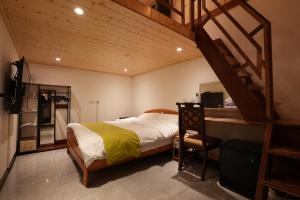 - une chambre avec un lit, un bureau et un escalier dans l'établissement Lemuju B&B Hotel, à Daxi