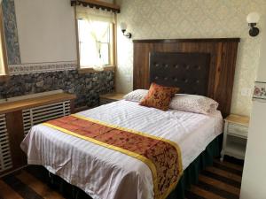 a bedroom with a large bed with a wooden headboard at Heritage Place Hotel in Gravelbourg