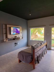 una camera con letto e TV a parete di Casa con piscina y patio a 20 minutos de la ciudad a Villa Dolores