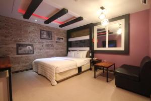um quarto com uma cama e uma parede de tijolos em v motel em Busan