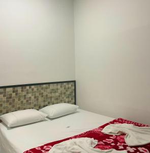 Una cama con sábanas blancas y una manta roja. en Apartahotel El paraiso, en Cali
