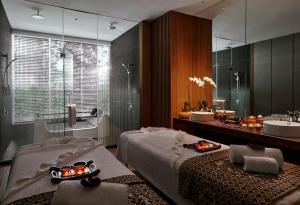 Pan Pacific Serviced Suites Kuala Lumpur في كوالالمبور: حمام بسريرين ومغسلة ومرآة