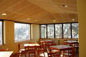 a dining room with tables and chairs and windows at Alberg Núria Xanascat in Queralbs +38 photos