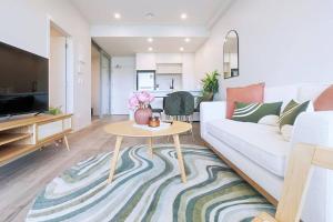 sala de estar con sofá blanco y mesa en Brand new stylish 2BR apartment- free parking, en Auckland