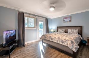 a bedroom with a bed and a flat screen tv at CHEERFuL 2 LEVEL HOUSE 4 BED 3 BATH PARKiNG in Delta