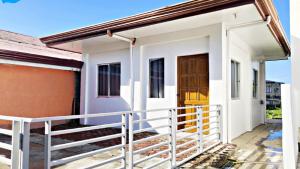 a white house with a gate and a door at Ormoc Mountain View House in Ormoc