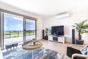 a living room with a table and a large window at Ocean Vista in Lakes Entrance