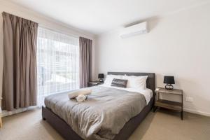 a bedroom with a bed and a large window at Ocean Vista in Lakes Entrance