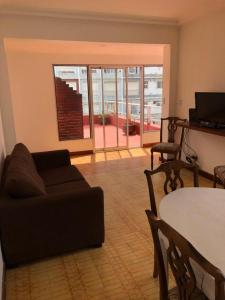 sala de estar con sofá y mesa en Check and Home - Sacoa - 6 huéspedes con vista al mar, terraza privada y parrilla en Mar del Plata