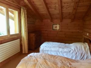 a bedroom with two beds in a log cabin at Chalet spacieux 13 couchages proche pistes à Demi-Quartier - FR-1-560-36 in Demi-Quartier