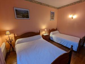 a bedroom with two beds and two lamps on the wall at Maison de plain-pied avec jardin clos, jeux enfants, vélos, animaux acceptés, proche Montbron - FR-1-653-6 in Vouthon