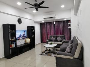 a living room with two couches and a tv at Coco HomeStay 旅人の家@The Venus Sitiawan Perak in Sitiawan