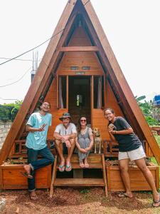 un grupo de personas sentadas frente a una casa pequeña en Sinuan homestay- Jabu 02 en Pandanga